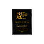 A photo of a Black Piano Finish plaque with full laser engraved text and graphics, and colour fill.