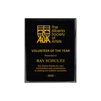 A photo of a Black Piano Finish plaque with full laser engraved text and graphics, and colour fill.