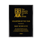 A photo of a Black Piano Finish plaque with full laser engraved text and graphics, and colour fill.