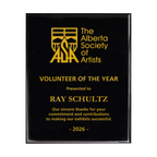 A photo of a Black Piano Finish plaque with full laser engraved text and graphics, and colour fill.