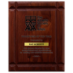 A photo of a solid wood Deep Groove Walnut plaque with a laser engrave text and graphics, and a traditional engraved plate.